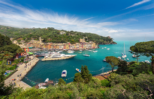 Aerial panoramic view of Portofino, the colorful coastal italian village in the province of Liguria, Italy - Multicolored houses and villas, fishing boats and luxury yachts in the little bay harbor