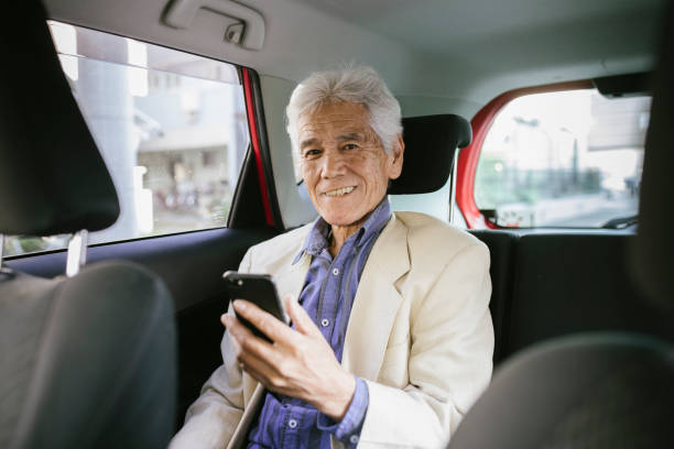 retrato do homem asiático sênior tomando s crowdsourced taxi - rush hour commuter on the phone tokyo prefecture - fotografias e filmes do acervo