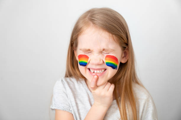 istock kid painted cheeks a rainbow. stay home. 1220567925
