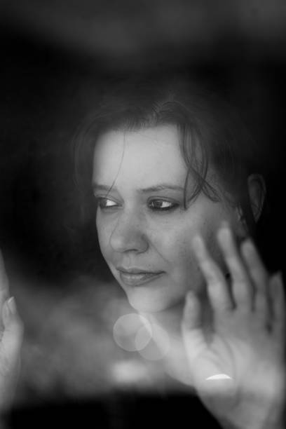 istock Depressed woman looking out of window 1220568067