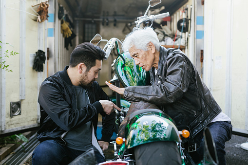 Father and son spending time together and fixing a motorcycle