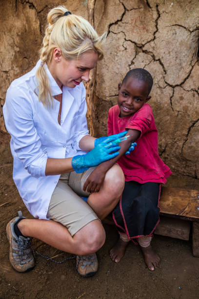 医師は小さな村、ケニアで小さなアフリカの女の子に注射をしています - little girls vaccination child caucasian ストックフォトと画像