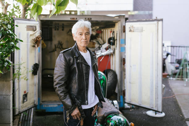 Senior Biker with Motorcycle in Front of his Garage
