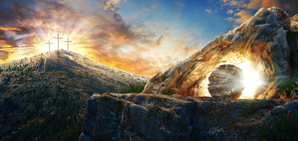 istock High resolution. Easter Sunday concept: Empty tomb stone with cross on meadow sunrise background. 3d rendering 1220573431