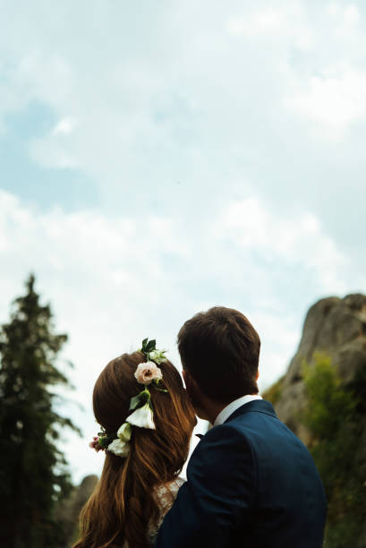 istock stylish boho bride and elegant groom looking at sky and hugging, happiness togetherness concept 1220575117