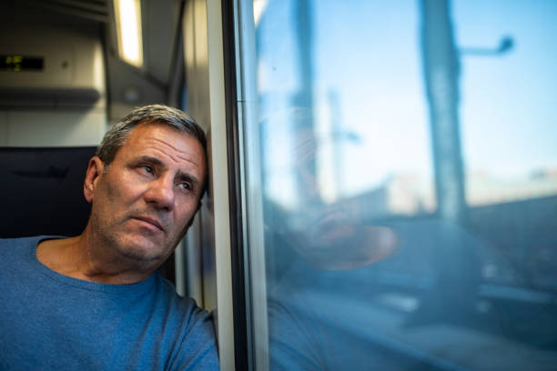 istock Tired tourist looking through the window while traveling by passenger train 1220575759