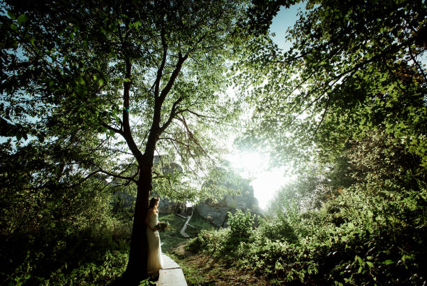 istock stylish bohemian bride standing in light in the sunny woods 1220577655