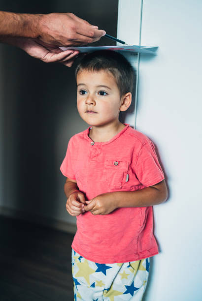 istock Father measuring son's height 1220581539
