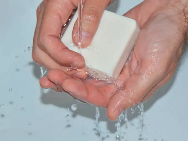 Man washing his hands with soap under running water