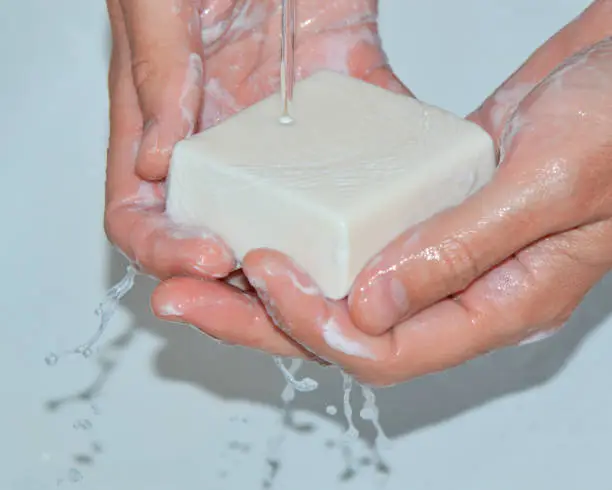 Man washing his hands with soap under running water