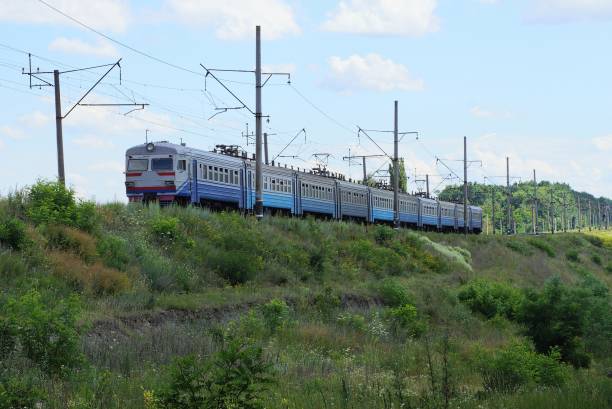 istock blue passenger train travels by rail along green vegetation 1220583538