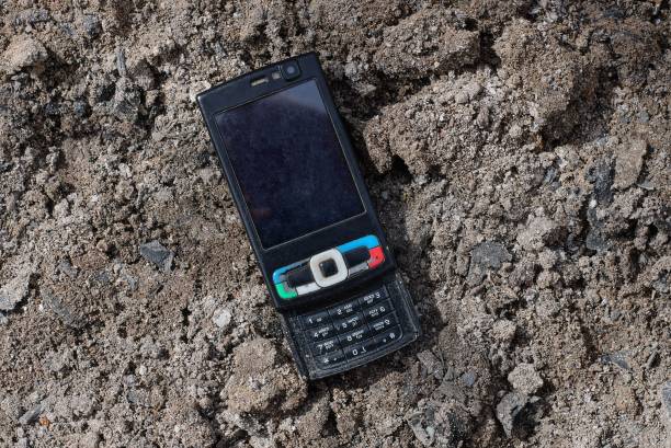 istock one black old mobile phone lies on gray earth 1220583718