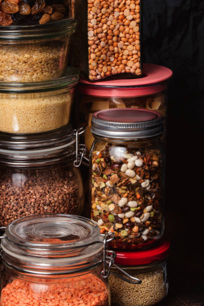 istock Various seeds in storage jars in pantry, dark textured background. Smart kitchen organization 1220584324