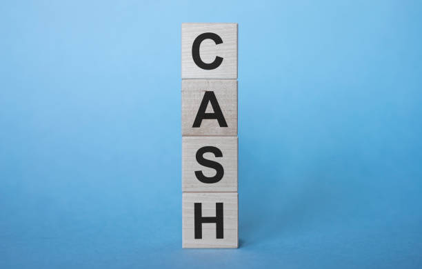 istock CASH word concept written on wooden cube blocks lying on a light table and light blue background 1220585160