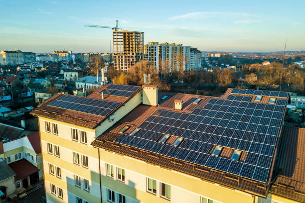 vue aérienne de nombreux panneaux solaires voltaiques photo montés sur le toit du bâtiment industriel. - voltaic photos et images de collection