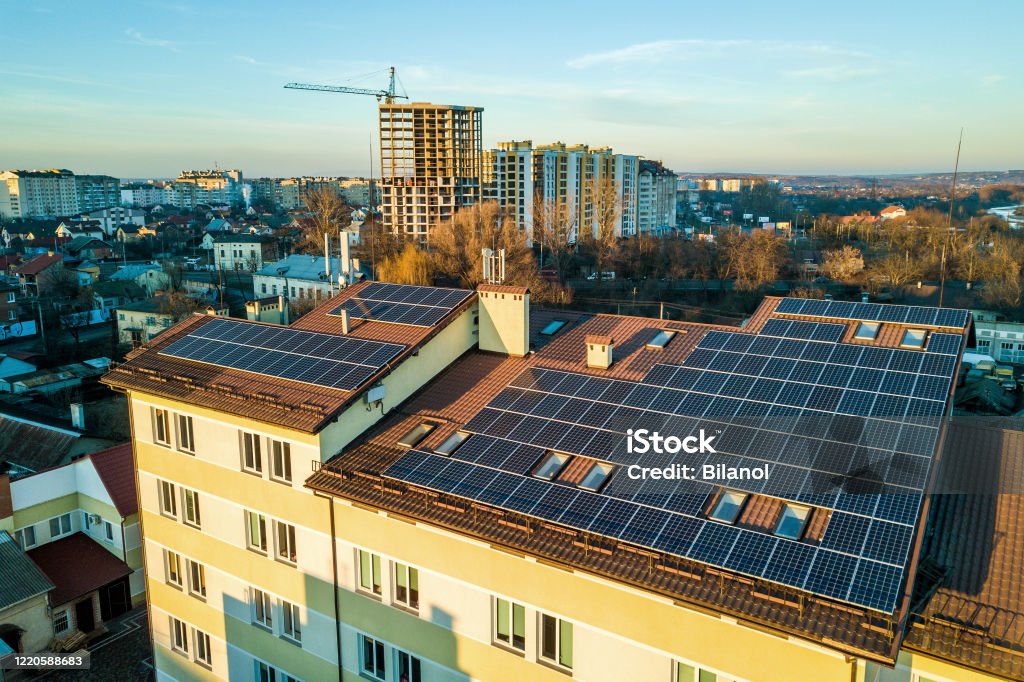 Aerial view of many photo voltaic solar panels mounted of industrial building roof. Solar Panel Stock Photo