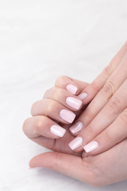 istock Pink colored nails on woman hands with copy space. 1220589425