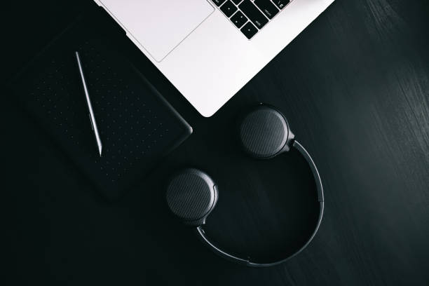 istock Dark modern workplace with a graphic tablet, laptop, wireless headphones 1220590047