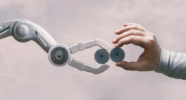 roboter und menschliche hand mit zahnrädern - künstliche intelligenz stock-fotos und bilder
