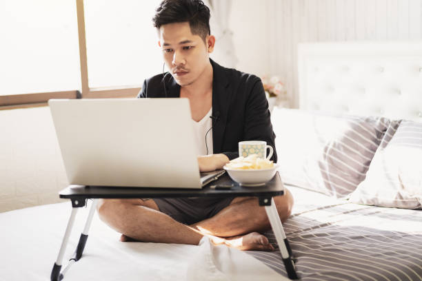 istock Businessman sit on the bed doing work from home 1220593353