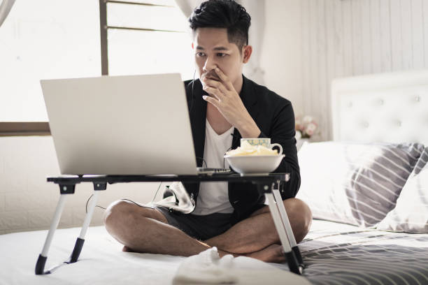istock Businessman sit on the bed doing work from home 1220593400