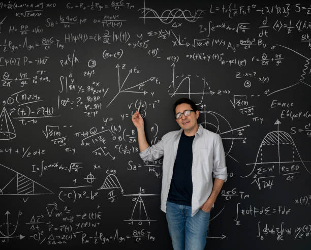 professeur de physique pointant vers des équations de maths écrites sur un tableau noir - formula blackboard complexity scientist photos et images de collection
