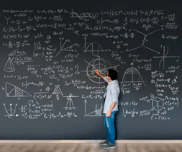 Photo of Math teacher writing formulas on a blackboard