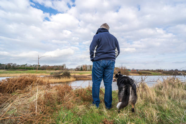 istock Man on grassland with border collie 1220593869