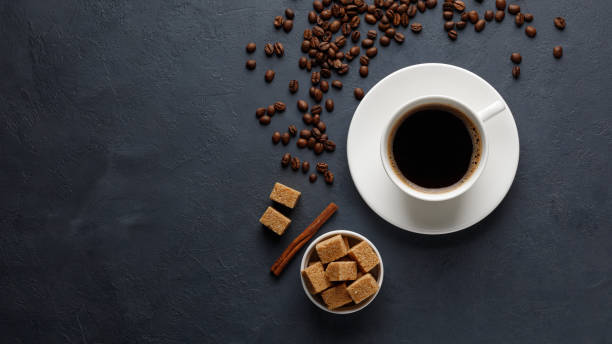 istock Mug of coffee, coffee beans and brown sugar on the kitchen table. 1220597405
