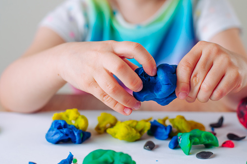 Primer plano de las manos de los niños moldeando arcilla de juego colorido del niño photo