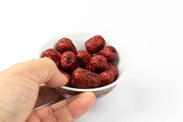 istock A bowl of Chinese dried red date fruit on white background. 1220602944