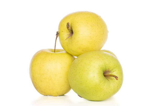 Group of three whole green delicious apple isolated on white
