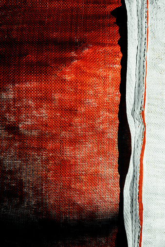 Distressed woven red fabric outdoors.