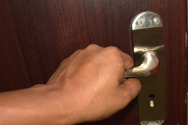 istock things and objects in everyday life and human life through which germs and viruses spread, door handle in an apartment in a room or house with hand and finger 1220607432