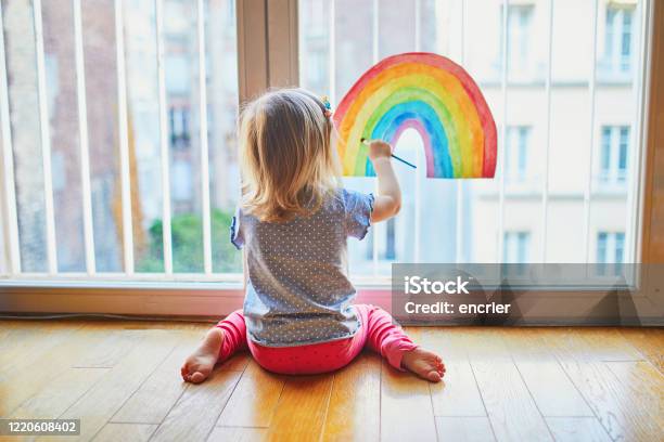 Adorable Toddler Girl Painting Rainbow On The Window Glass Stock Photo - Download Image Now