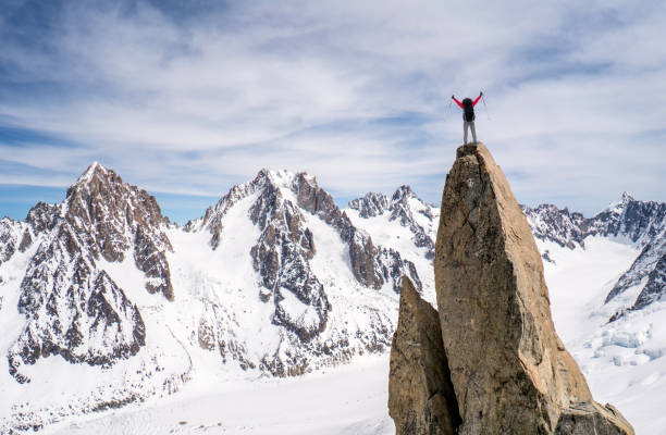 Excited climber reaching the top of a mountain - conquering adversity concepts