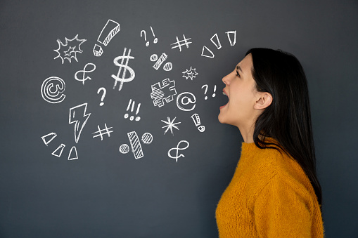 Portrait of an angry young woman cursing and symbols written on a blackboard - illustration concepts