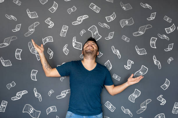 Excited man under a shower of money Excited man under a shower of money with bills floating in the air - economy concepts money rain stock pictures, royalty-free photos & images