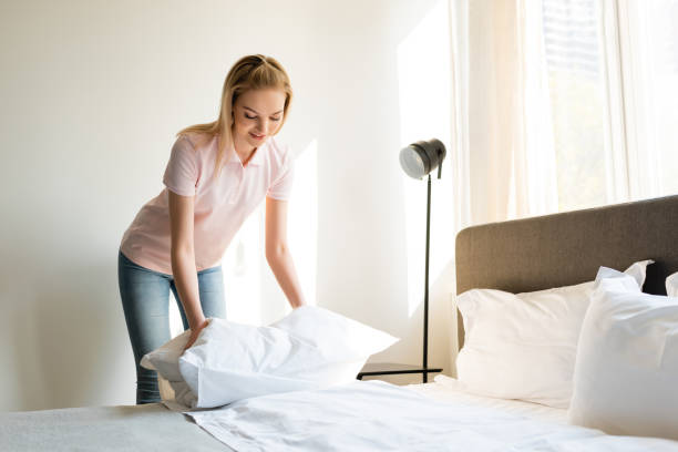 istock happy woman touching pillow in bedroom 1220611317