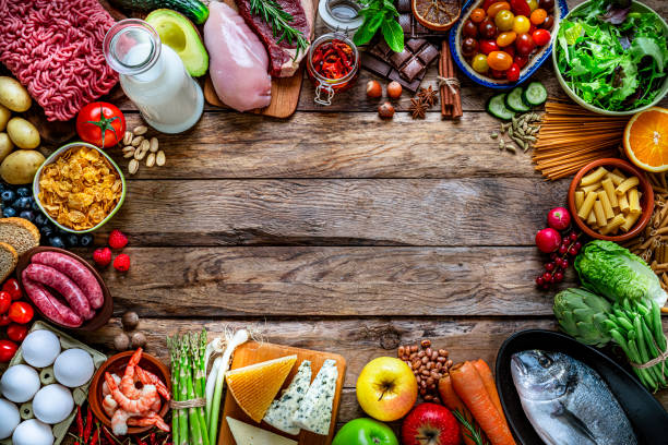 istock Food backgrounds: large variety of food making a frame on rustic wooden table. Copy space 1220615742