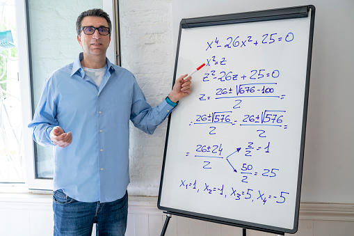 Maths teacher man teaching on white board pointing equation from home e-learning