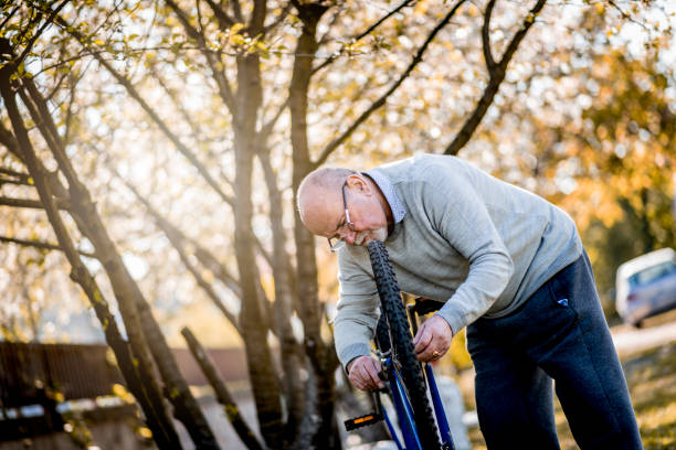 istock Senior man repairing bicycle 1220621019