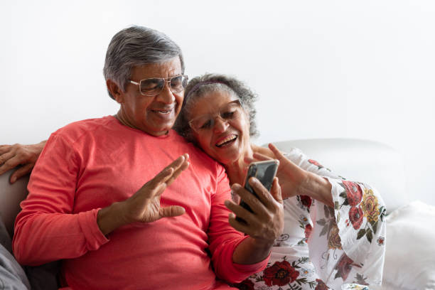 Senior couple chatting by video conference Seniors in confinement talking by video conference DisruptAgingCollection stock pictures, royalty-free photos & images