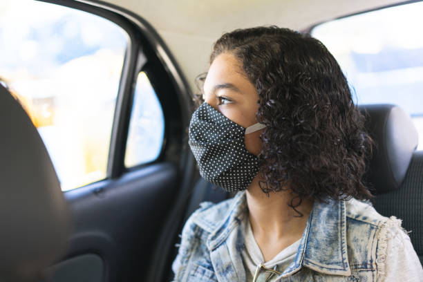 Teenager wearing N95 face mask on car trip Teenager wearing N95 face mask on car trip during the coronavirus pandemic in 2020 alcove stock pictures, royalty-free photos & images