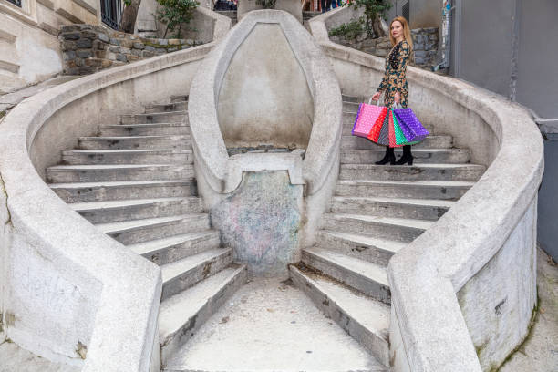 giovane donna in possesso di borsa della spesa colorata con un sorriso felice. camondo stairs (turco: kamondo merdivenleri) nel distretto di galata a istanbul, turchia. - camondo foto e immagini stock