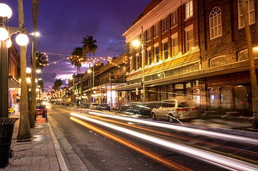 People walk along the downtown nightlife of bars and restaurants in historic Ybor City Tampa Florida USA