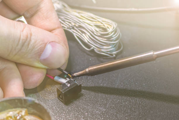 istock technical master soldering parts with a soldering iron. technical support, repair 1220624751