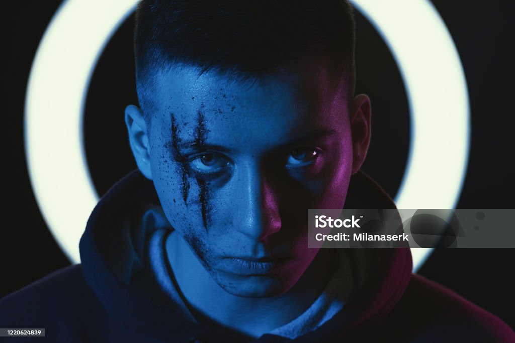 Teenage boy with wounds on face for book cover and poster ideas. Scary teenage boy with wounds on face for book cover and poster ideas. Adult Stock Photo