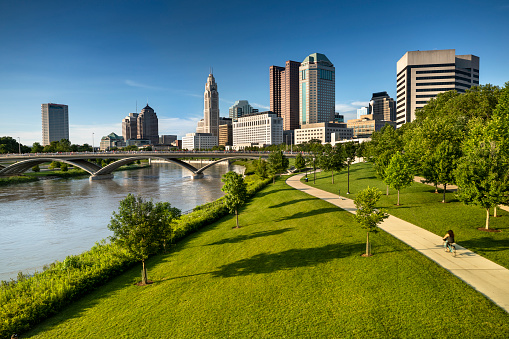 Downtown cityscape looking over the Scioto River and the Discovery Bridge along the Riverfront Park in the city of Columbus Ohio USA