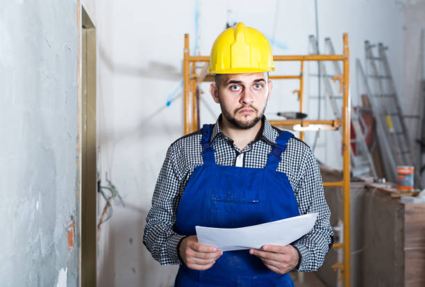 istock Plasterer is looking on the project of work for the object. 1220627552